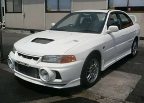 White JDM 1996 Lancer Evolution IV with hallmark fog lights and twin-turbocharged engine